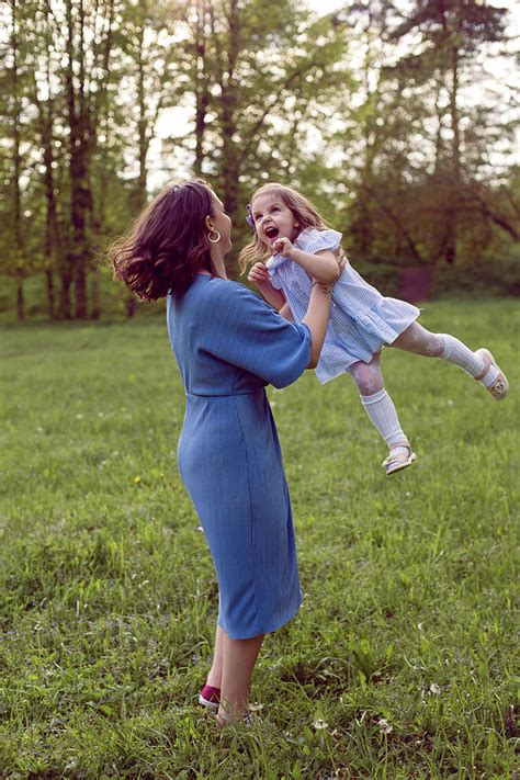 Mother And Daughter In A Blue Dress Are Played In The Spring Photograph