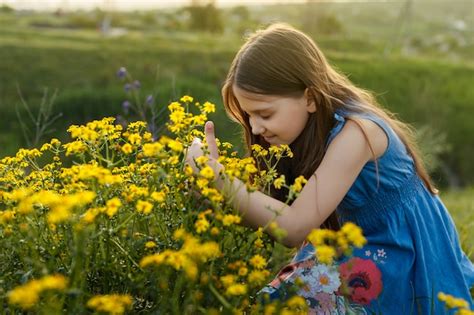 Girl Smelling Wild Flowers In The Meadow Free Photo