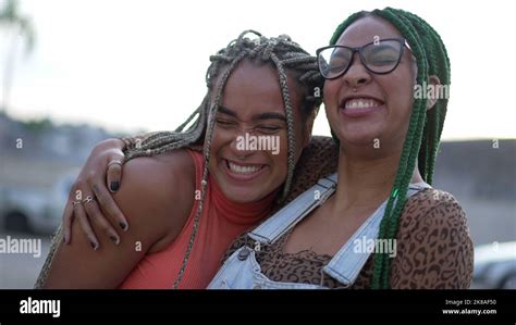Two Hispanic Black Women Embrace South American Brazilian Sisters Hugging Posing Outdoors