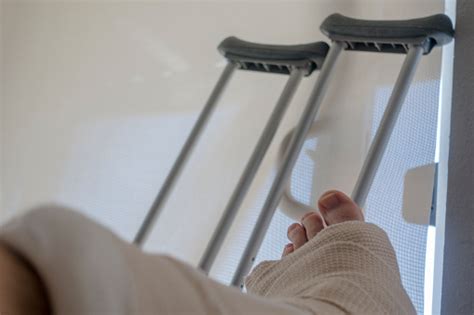 Injured Person With Sprained Or Broken Ankle Foot Crutches Stock Photo