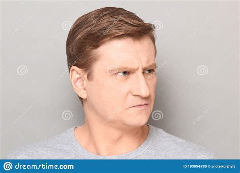 Portrait Of Angry Disgruntled Mature Man With Frowning Face Stock Photo