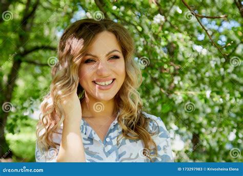 Portrait Of A Beautiful Blonde Girl With Green Eyes And Blossoming