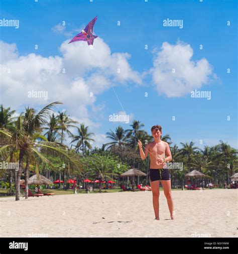 Teenager Boy Flying A Kite On Tropical Beach Kids Beach Activities