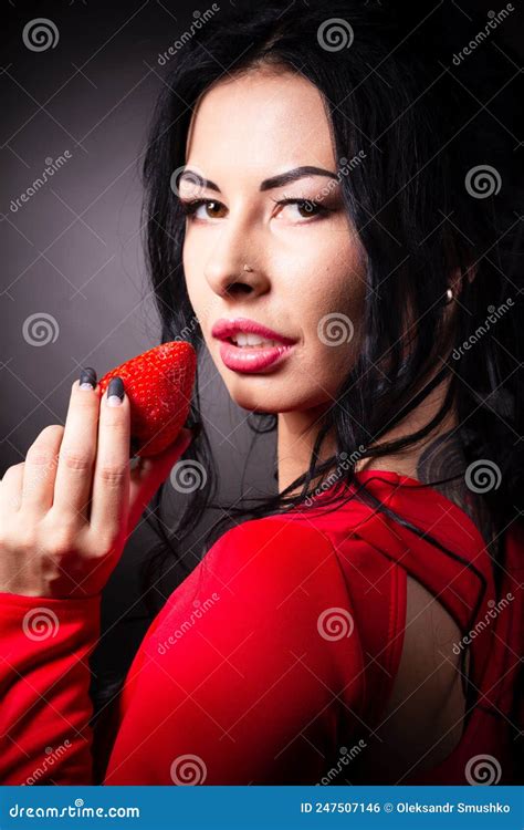 Portrait Of A Brunette Beauty With Honey Dripping Strawberry Stock
