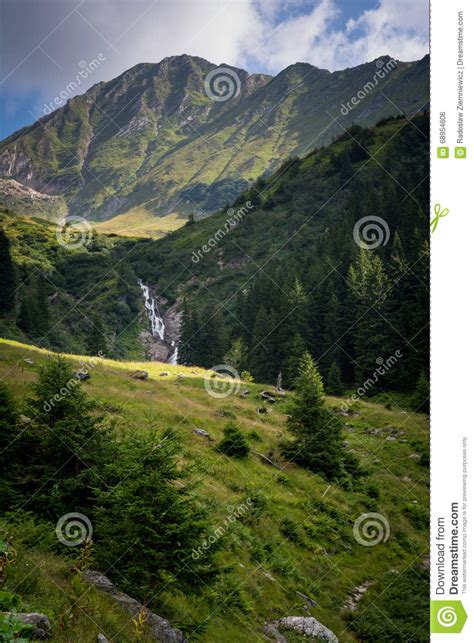 Beautiful Waterfall In The Scenery Of Green Mountains In