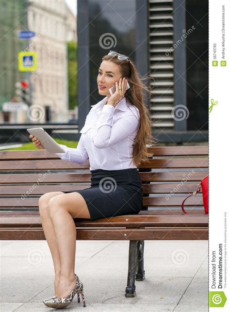 Jonge Mooie Bedrijfsvrouwenzitting Op Een Bank In Zonnig C Stock