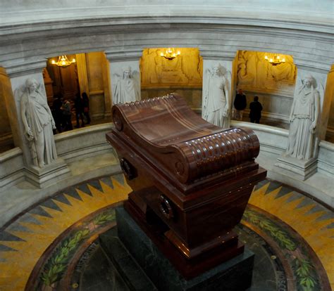 A Large Wooden Casket Sitting In The Middle Of A Room With Statues On