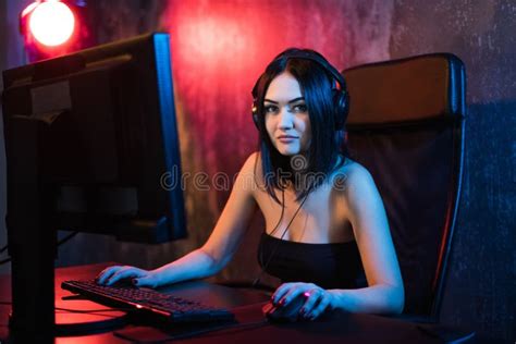 A Cute Female Gamer Girl Sits In A Cozy Room Behind A Computer And