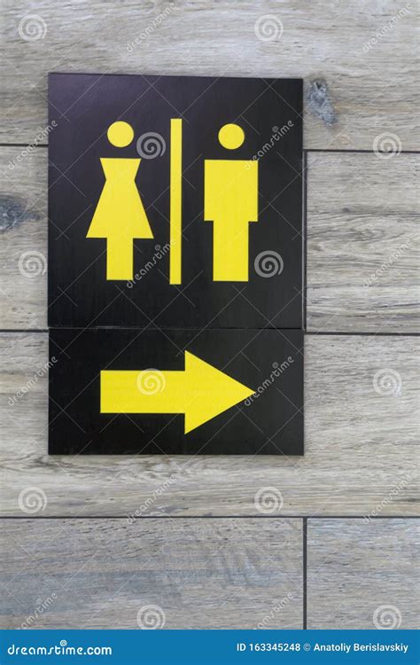 Sign With Arrow Pointing Direction To Male And Female Restrooms Stock