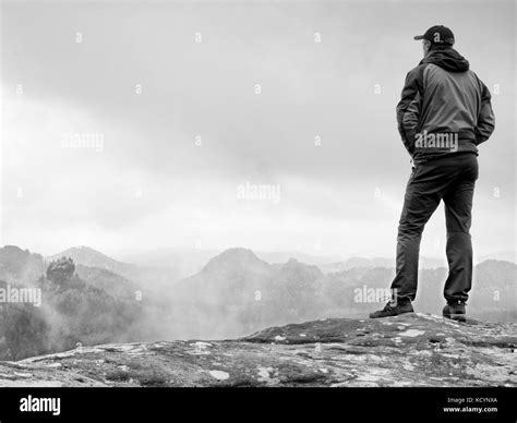 Hiker On Rock End Above Valley Man Watch Over Misty And Foggy Morning