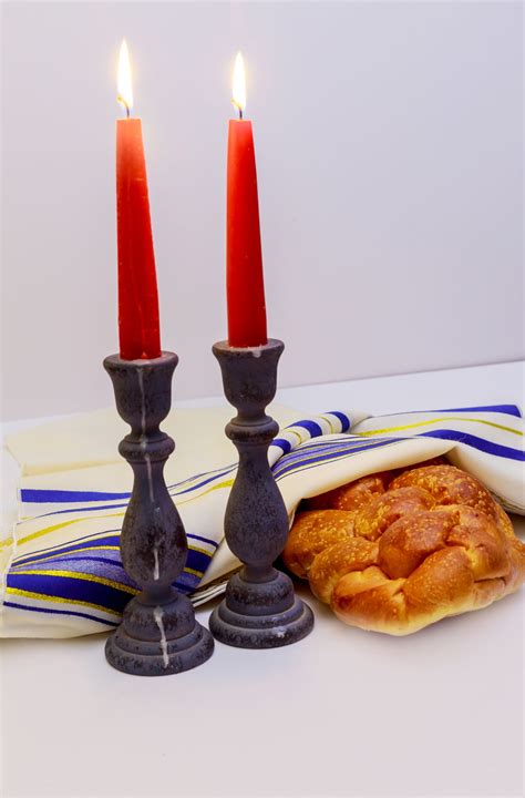 A Table Set For Shabbat With Lighted Candles Challah Bread And Wine
