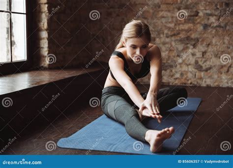 Pretty Young Fitness Woman Sitting And Stretching Her Legs Stock Image