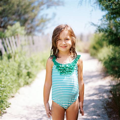 Cute Young Girl Standing By A Beach Walkway In A Bathing Suit By