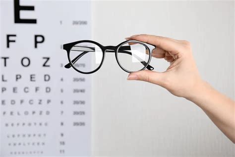 Woman Holding Glasses Eye Chart Light Background Closeup