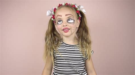 A Little Girl With Make Up On Her Face Depicts Puppet Grimaces Mime