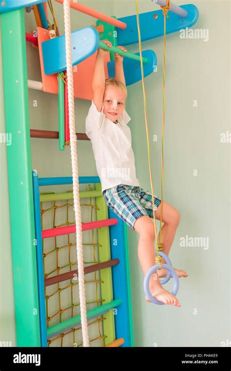 Happy Little Boy Hanging On Rings On Home Wall Gym Childs Sportive
