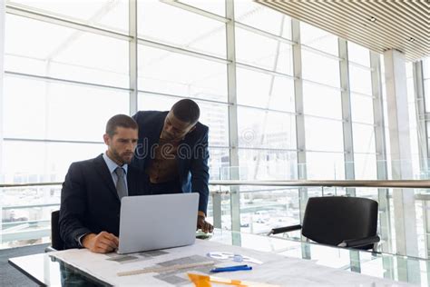 Two Businessmen Looking At Laptop Together In An Office Stock Photo