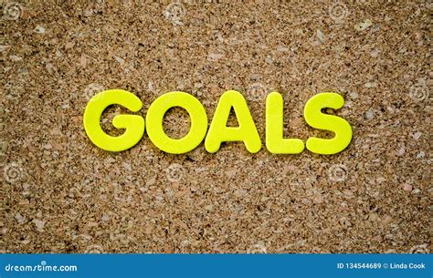 The Word Goals Spelled Out In Yellow Letters On A Cork Board Stock