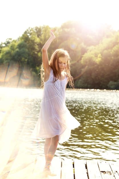 Premium Photo A Girl In A Wet White Dress Dancing Near The River
