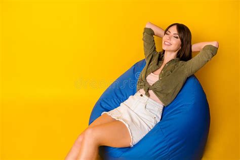 Photo Of Lady Sit Beanbag Eyes Closed Hands Behind Head Wear Green Shirt Short Skirt Isolated