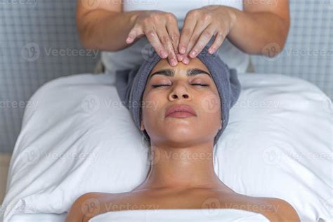 Esthetician Giving A Facial Massage With Cream On A Relaxed Woman S Face At Health Spa 19986972