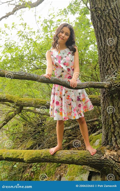 Grinning Teenage Girl Standing On Branch Of An Old Tree Stock Image