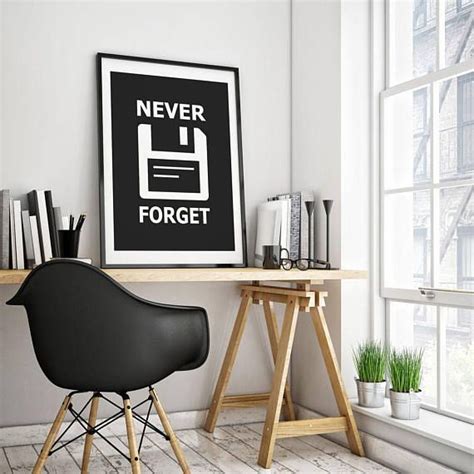 A Black Chair Sitting Next To A Wooden Table In Front Of A Framed Art Piece