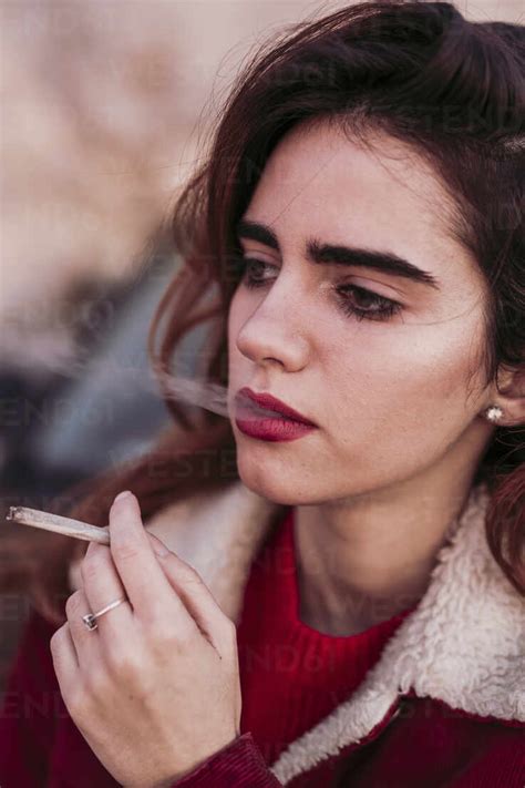 Close Up Of Thoughtful Beautiful Woman Smoking Cigarette Stock Photo