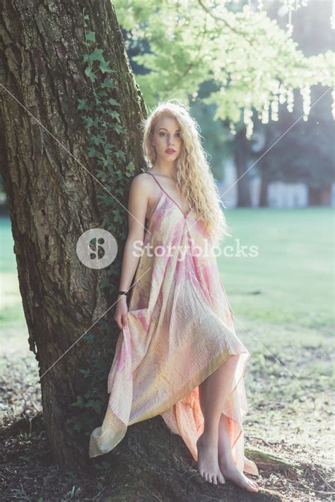 Enchanting Concept Woman In Pink Dress Leaning On A Tree In The Forest