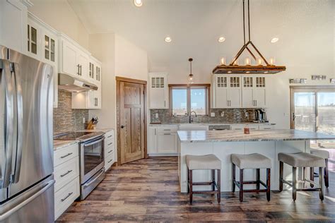 Sink base cabinet has 2 wood drawer boxes that offer a wide variety of storage possibilities. White Open Concept Kitchen with Stainless Steel Appliances, Island, White Cabinets, and Walk-In ...