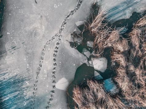 Panoramic Aerial View Of A Frozen Lake With Animal Tracks And Cracked