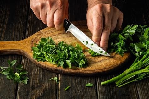 Premium Photo Chef Hands Cutting Green Parsley Leaves On Cutting