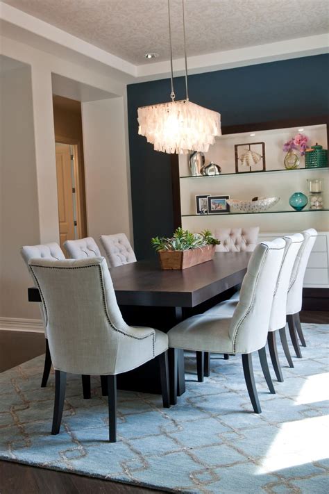 Select from round, oval, rectangular, and extension dining tables; Eight off-white tufted chairs surround a dark wood table ...