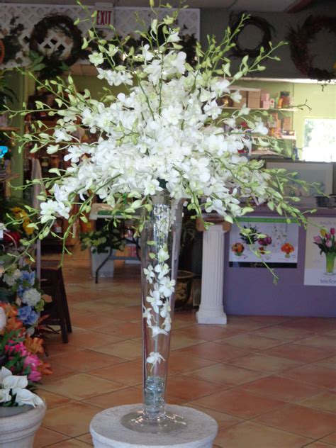Centerpiece Of White Dendrobium Orchids On A Trumpet Vase Designed By