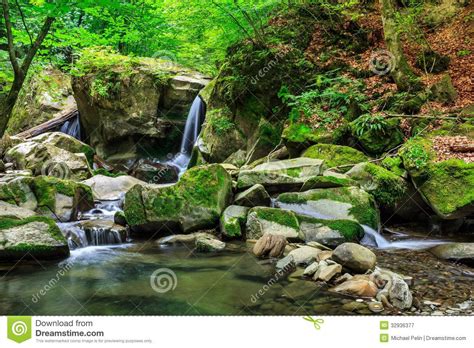 Beautiful Waterfall Comes Out Of A Huge Rock In The Forest Stock