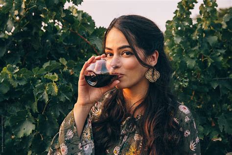 pretty latina woman drinking wine by stocksy contributor jayme burrows stocksy