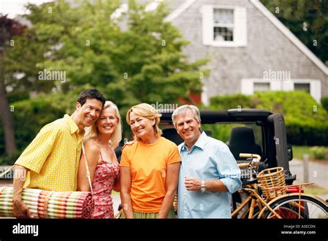 Portrait Of Two Mature Couples Standing And Smiling Together Stock