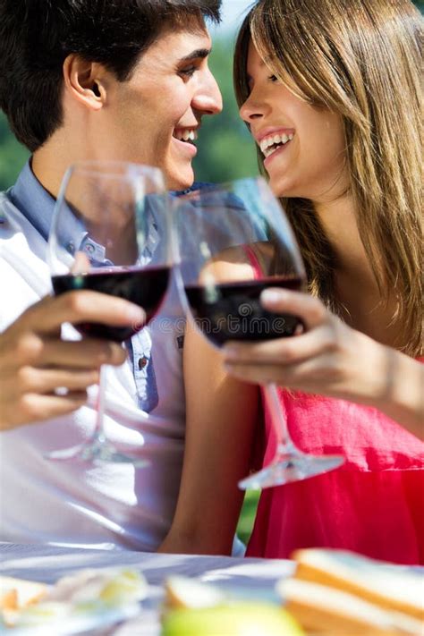 Attractive Couple Drinking Wine On Romantic Picnic In Countryside