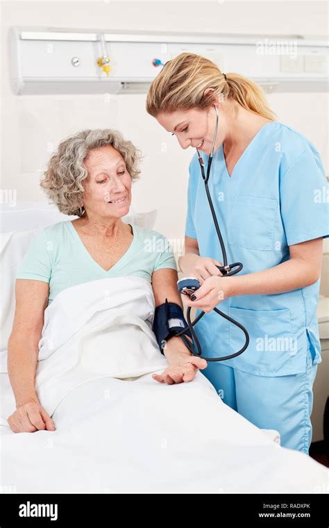Nurse Measuring Blood Pressure In A Senior Patient Stock Photo Alamy