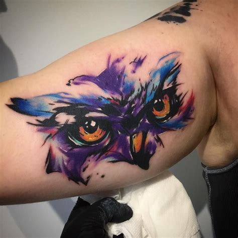 An Owl Tattoo On The Left Arm And Shoulder With Colorful Feathers In It