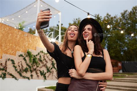 Joyful Women Taking Selfies On Smartphone On Decorated Scene In Sunny