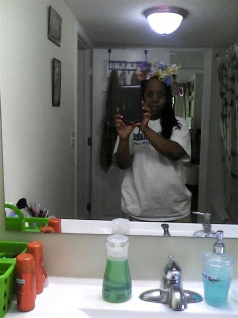A Woman Taking A Selfie In Front Of A Bathroom Mirror While Holding A Cell Phone