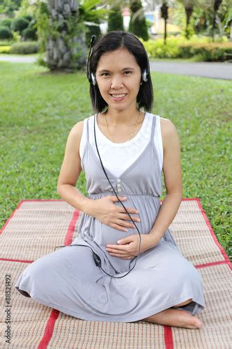 Thai Pregnant Mom Was Listening To Music In The Garden Stock Photo