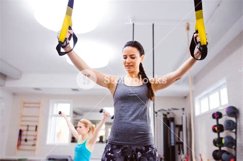 Fit Attractive Woman In Gym Training Arms With Trx Fitness Strips