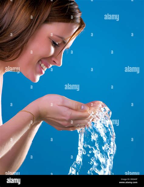 Beautiful Woman Washing Her Face Over Blue Background Stock Photo Alamy