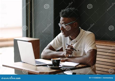 Freelancer Working On Laptop Computer At Coffee Shop Stock Photo