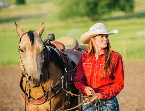 Caucasian Cowgirl Walking Horse On Ranch Stock Photo Dissolve