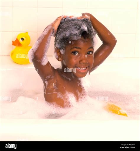 Young African American Girl Taking A Bubble Bath With Her Hands Stock
