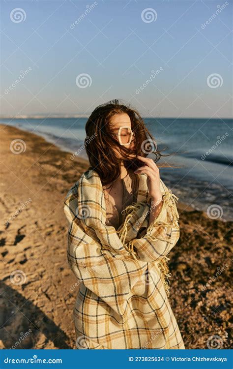 Portrait Of A Woman In A Blanket Standing On The Shore And