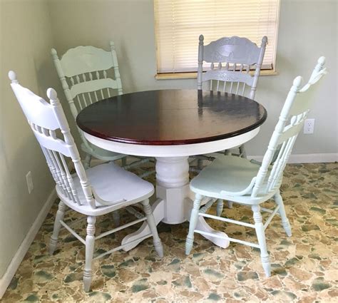 A Dining Room Table With Four Chairs And A Window In The Backround Area